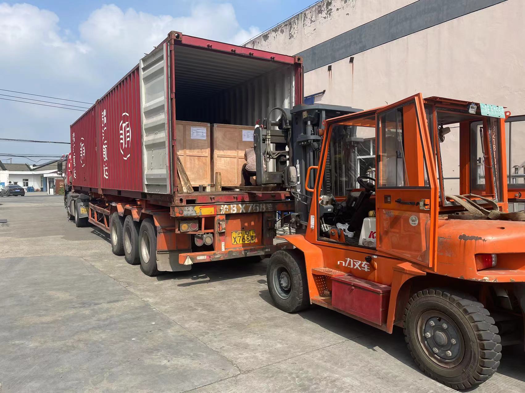 Forklift moving wooden transformer core cases into a shipping container